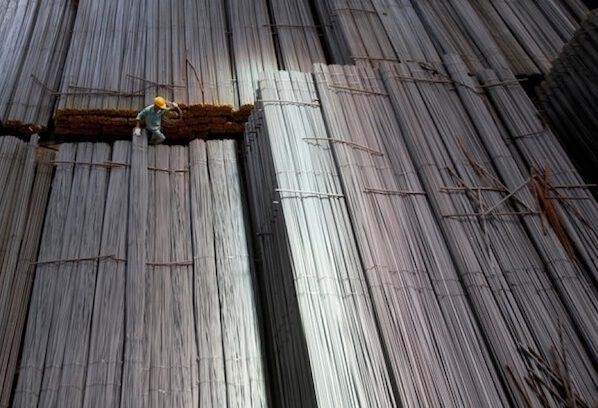 A man climbs on steel packages at Hoa Phat steel mill in Hai Duong Province, Vietnam. Photo by Reuters/Kham.